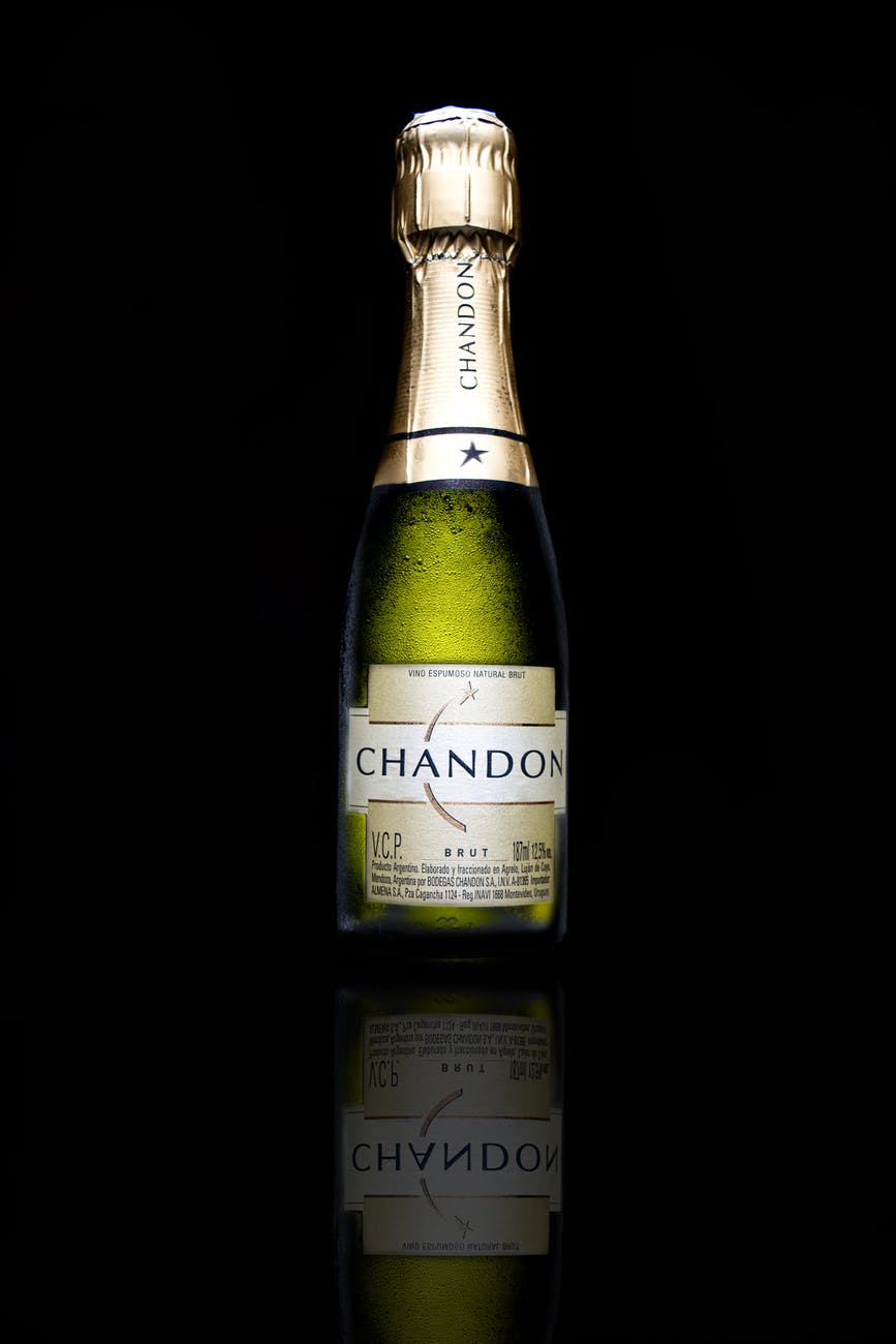 green champagne bottle with black background