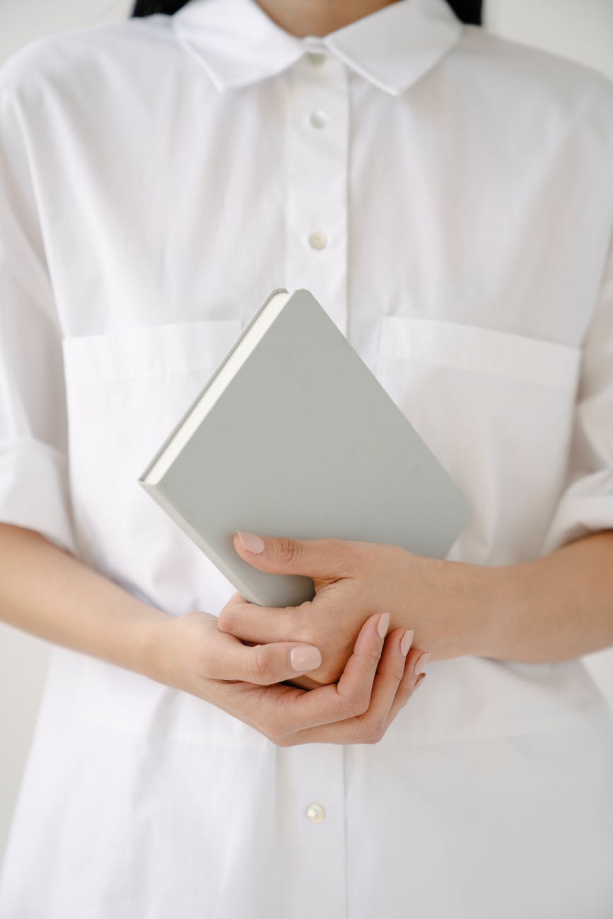 crop employee in white shirt with diary