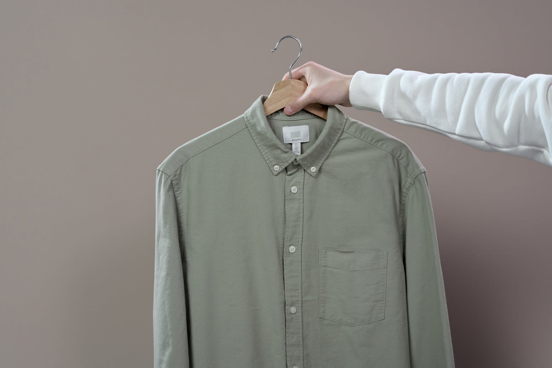 person holding green dress shirt