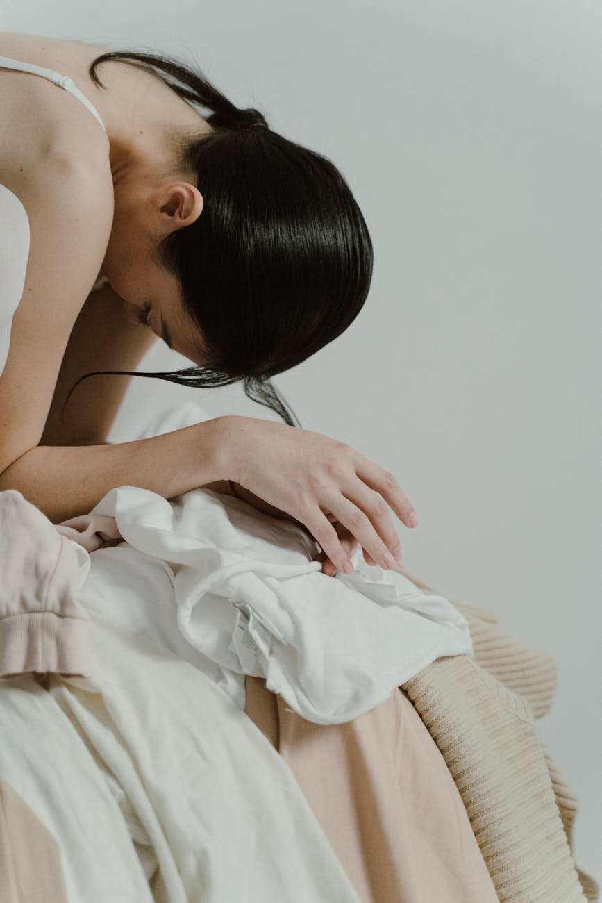 woman with her head down in a pile of fabrics