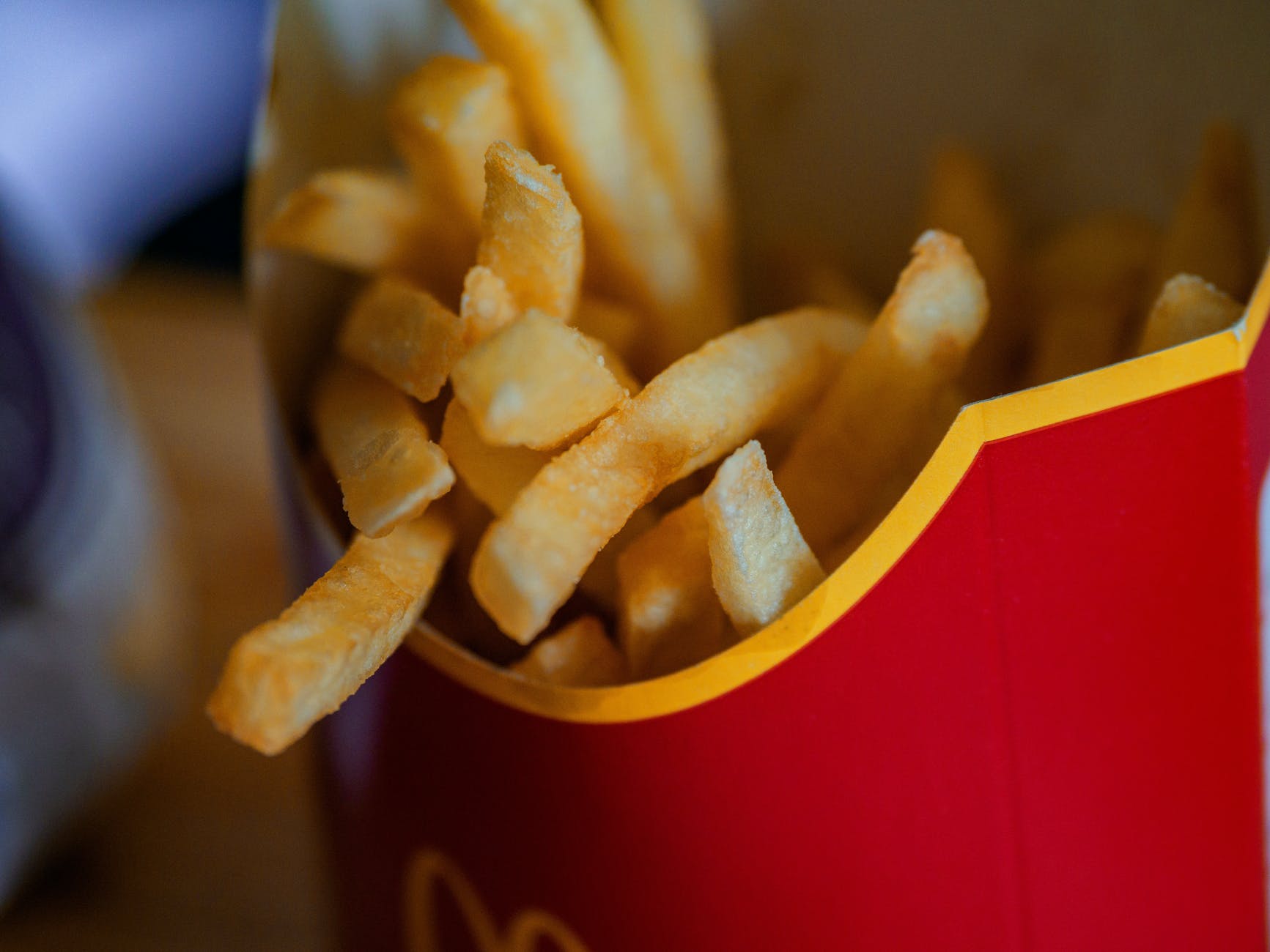 close up photo of french fries in a red container